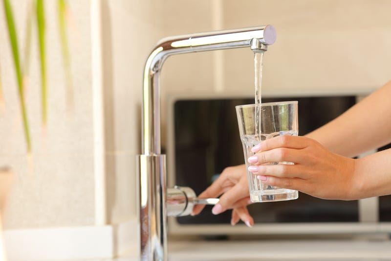 Woman pouring water from a faucet
