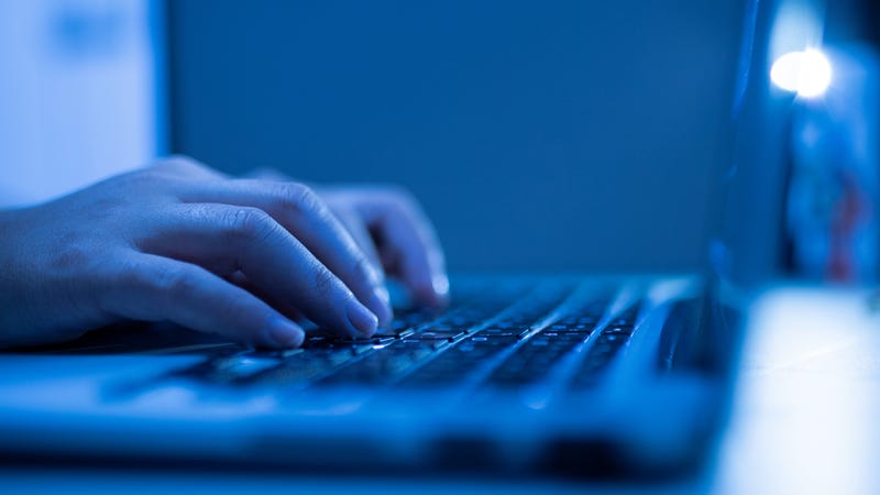 Hands typing on a laptop