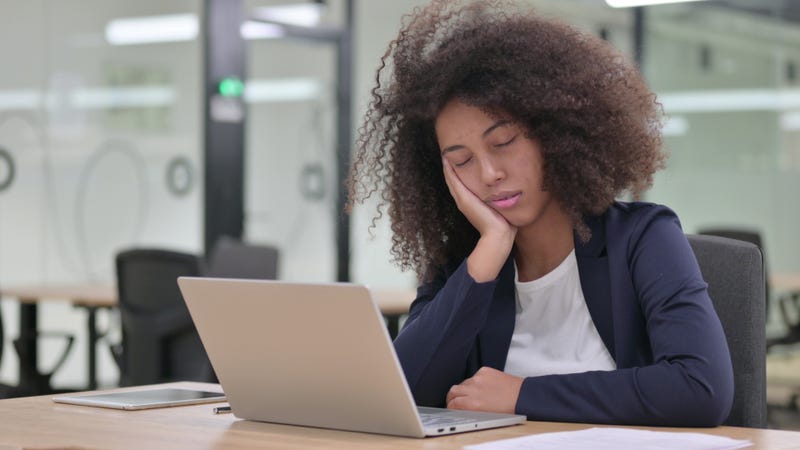Woman falling asleep at her computer