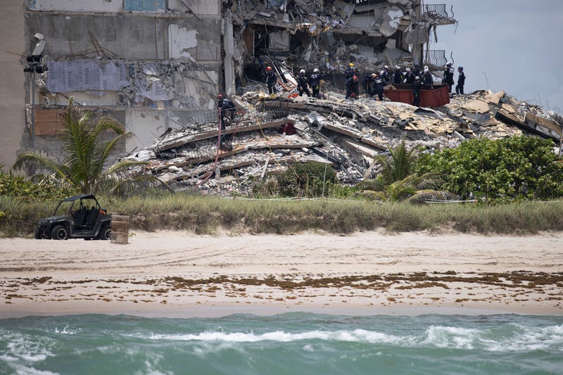 Members of the South Florida Urban Search and Rescue team look for possible survivors in the partially collapsed 12-story Champlain Towers South condo building