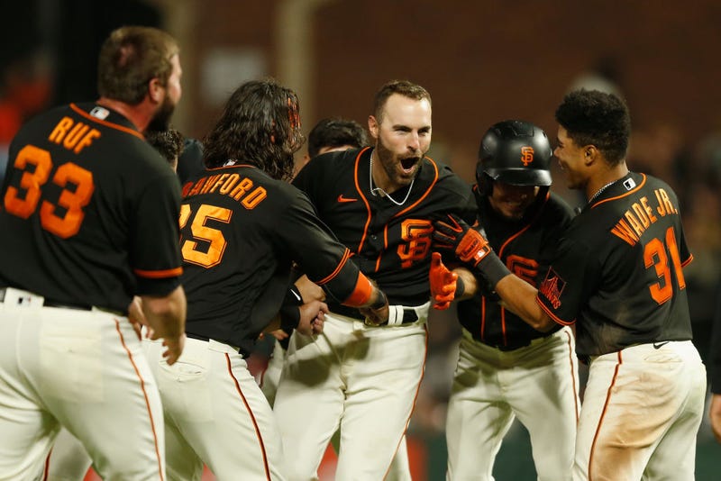 Curt Casali #2 of the San Francisco Giants celebrates with teammates after hitting a walk-off RBI double in the bottom of the tenth inning against the Oakland Athletics at Oracle Park on June 26, 2021 in San Francisco, California.