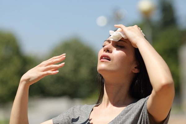 Woman wiping brow during hot summer day