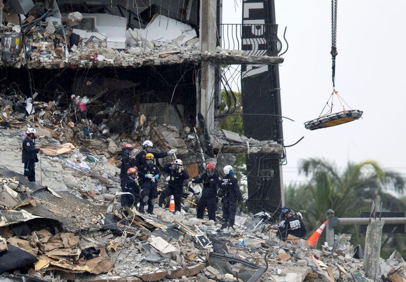 Search an Rescue personnel use a crane to remove a stretcher from the rubble of the partially collapsed 12-story Champlain Towers South condo building on June 28, 2021 in Surfside, Florida.