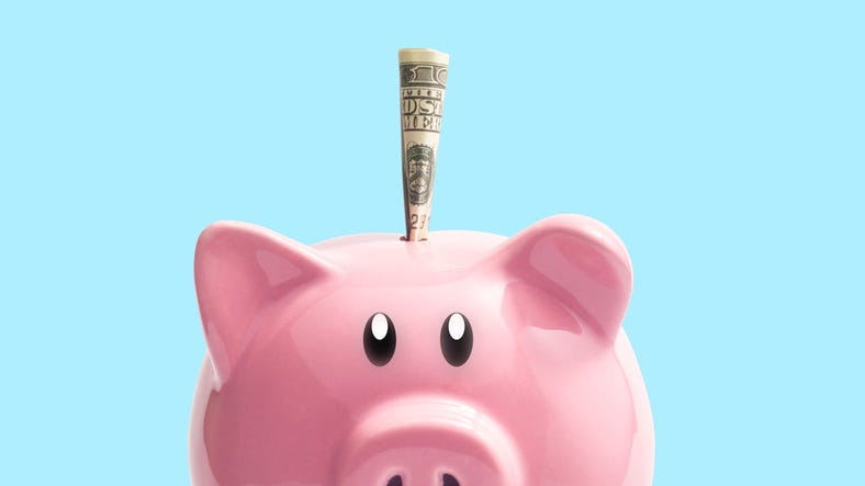 Money on a pink piggy bank on a blue background