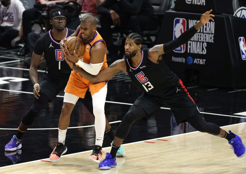 Chris Paul #3 of the Phoenix Suns protects the ball against Reggie Jackson #1 and Paul George #13 of the LA Clippers during the second half in Game Six of the Western Conference Finals at Staples Center on June 30, 2021 in Los Angeles, California. The Suns won, 130-103 to win the series.  (Photo by Harry How/Getty Images)