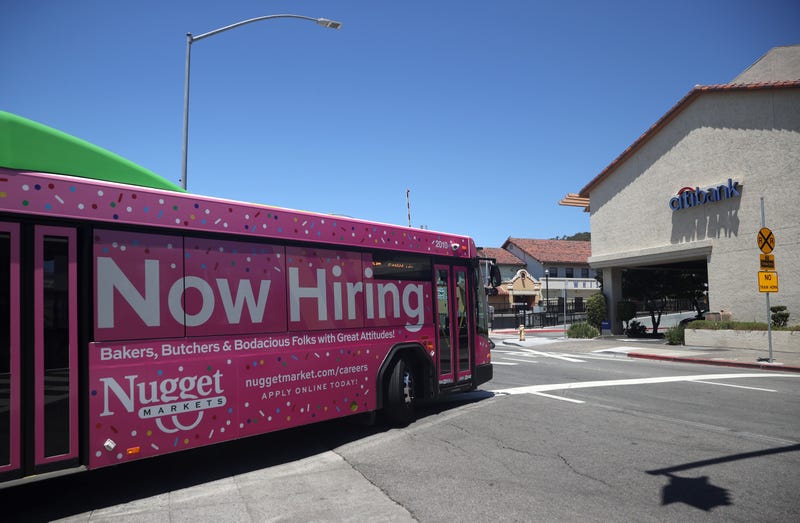 A "Now Hiring" sign for Nugget Markets is posted on the side of a Golden Gate Transit bus on July 07, 2021 in San Rafael, California.