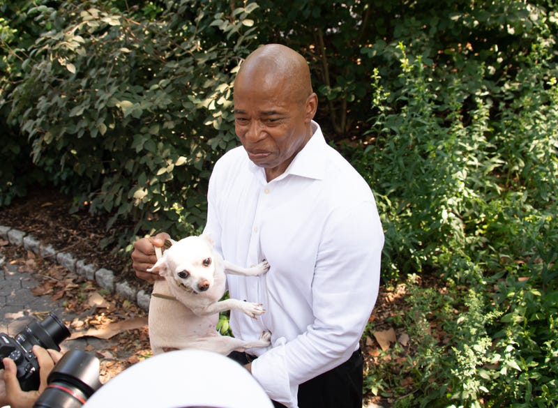 Then–mayoral candidate Eric Adams pets a dog at the "Hometown Heroes" Ticker Tape Parade on July 7, 2021 in New York