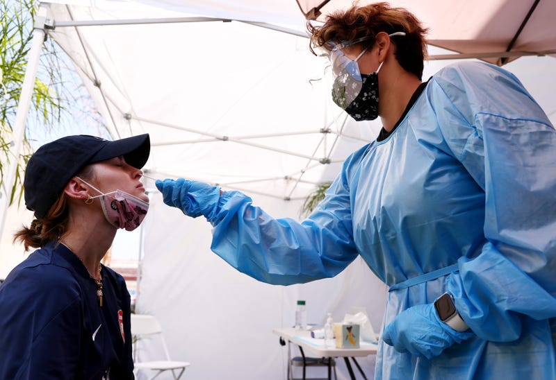 A medical assistant administers a COVID-19 test to a person at Sameday Testing on July 14, 2021 in Los Angeles, California.