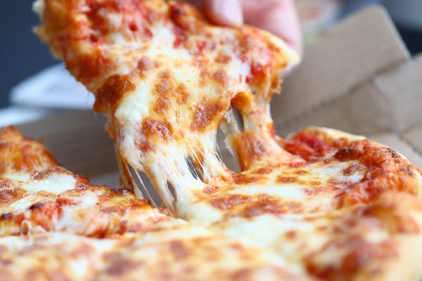Person taking a slice of cheese pizza