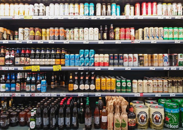 Beer bottles and cans on grocery store shelves