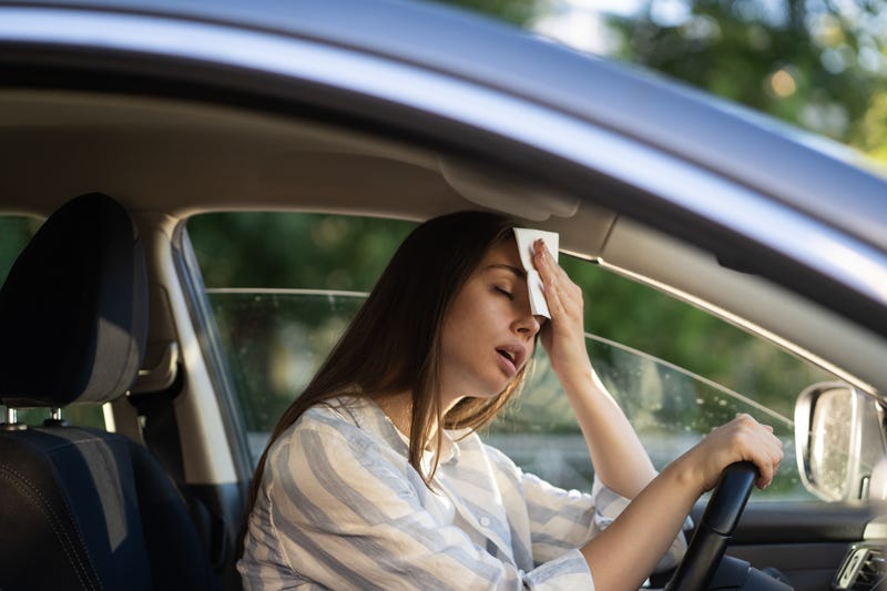 Woman in car sweating