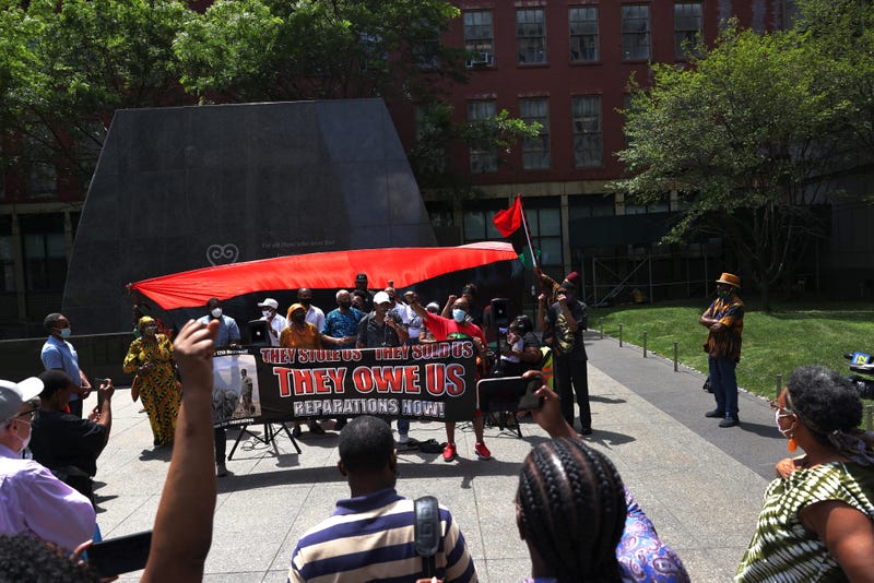 People listen to speakers during a rally for reparations at the African Burial Ground National Monument in Lower Manhattan on July 23, 2021