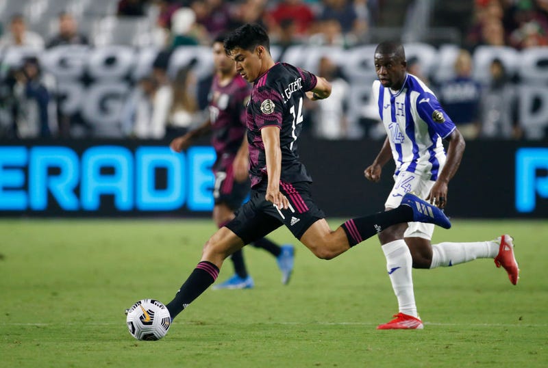 Erick Gutierrez #14 of Mexico makes a pass away from Boniek Garcia #14 of Honduras during the second half of the Concacaf Gold Cup quarterfinal match at State Farm Stadium on July 24, 2021 in Glendale, Arizona. 