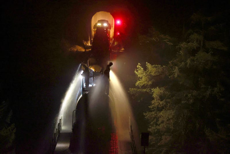 Union Pacific workers spray water along from a train along train tracks as the Dixie Fire burns in the area on July 26, 2021 near Quincy, California.