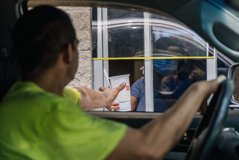 A customer receives his food in a McDonald's drive-thru on July 28, 2021 in Houston, Texas. McDonald's corporation has said that its sales are surpassing pre-pandemic levels across the world as more of its dining rooms reopen after being shutdown during the pandemic. The company has also said that menu-price increases, larger to-go orders and its new crispy chicken sandwiches have largely contributed to boosted sales across the U.S. (Photo by Brandon Bell/Getty Images)