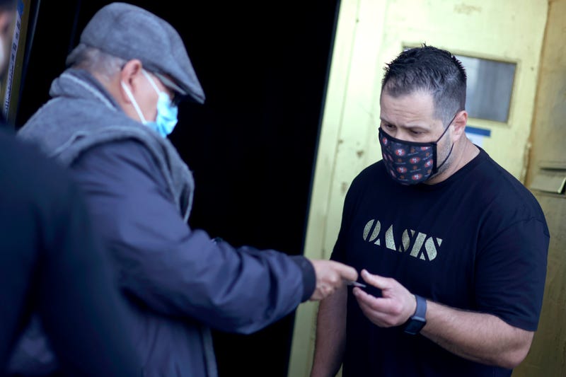 A doorman at Oasis checks a customer's vaccination card before allowing him to enter on July 29, 2021 in San Francisco,