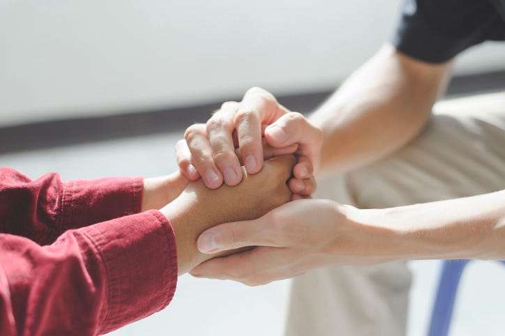Psychiatrist holding the hand of a patient