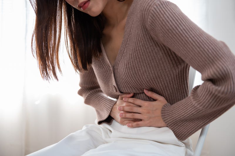 Stock image of person holding their stomach
