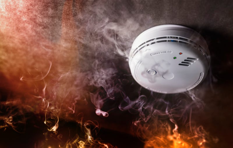 Smoke detector and fire alarm in action background 