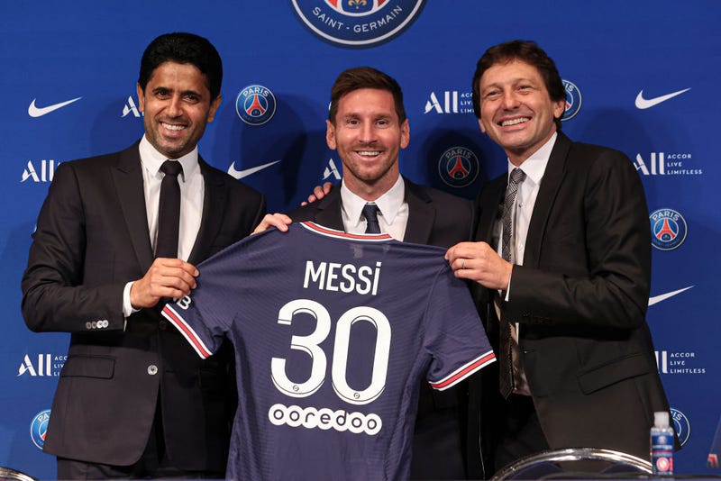 Lionel Messi poses with his jersey next to President Nasser Al Khelaifi and Leonardo after the press conference of Paris Saint-Germain at Parc des Princes on August 11, 2021 in Paris, France