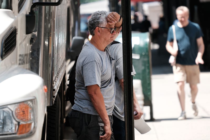 People walk through midtown Manhattan as temperatures reach into the 90's and with a heat index of over 100 degrees on August 10, 2021 in New York City