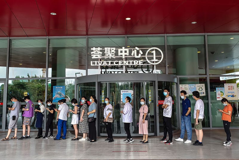 Employees line up for nucleic acid testing of Covid-19 in LIVAT Shopping Mall on August 11, 2021 in Wuhan, Hubei Province, China. Local media has reported new cases of Covid-19 as Wuhan launches a city-wide nucleic acid testing program. It is the first time new cases of community transmission have been recorded in Wuhan since May 2020. The new wave of Covid-19 started in Nanjing, prompting provinces and cities to take action to fend off the coronavirus. (Photo by Getty Images)