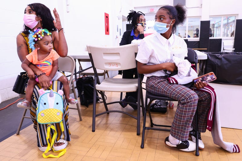 LaToya Feltus sits with her three daughters after the elder two both received a COVID-19 vaccination.