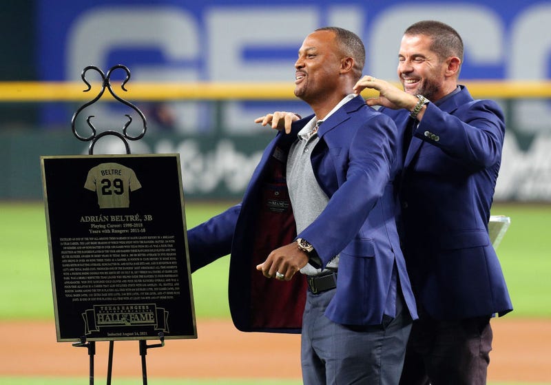Former Texas Rangers third baseman Adrian Beltre gets a jacket from former teammate Michael Young as he is inducted into the Texas Rangers Hall of Fame during a ceremony before the game against the Oakland Athletics at Globe Life Field on August 14, 2021 in Arlington, Texas.
