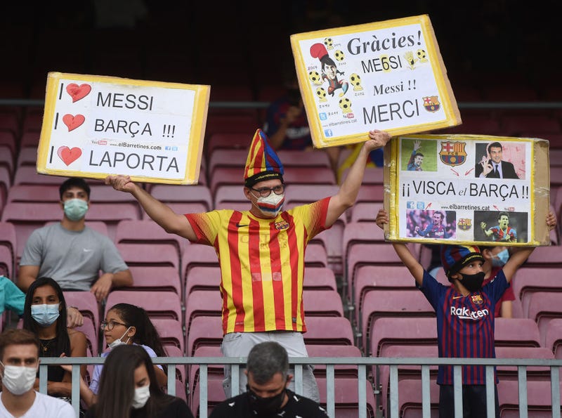 Fans of FC Barcelona hold aloft signs in support of the club and former player Lionel Messi prior to the LaLiga Santander match between FC Barcelona and Real Sociedad at Camp Nou on August 15, 2021 in Barcelona, Spain. 