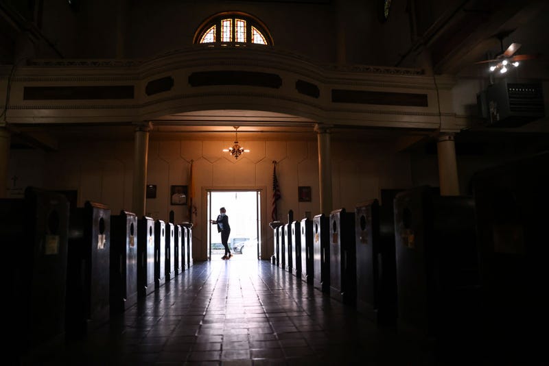 The head usher closes the church doors after Sunday Mass at St. Augustine Catholic Church on August 15, 2021 in New Orleans, Louisiana. Parishioners wore face coverings during Mass inside the historic church which is recognized as the oldest Black Catholic parish in the country.