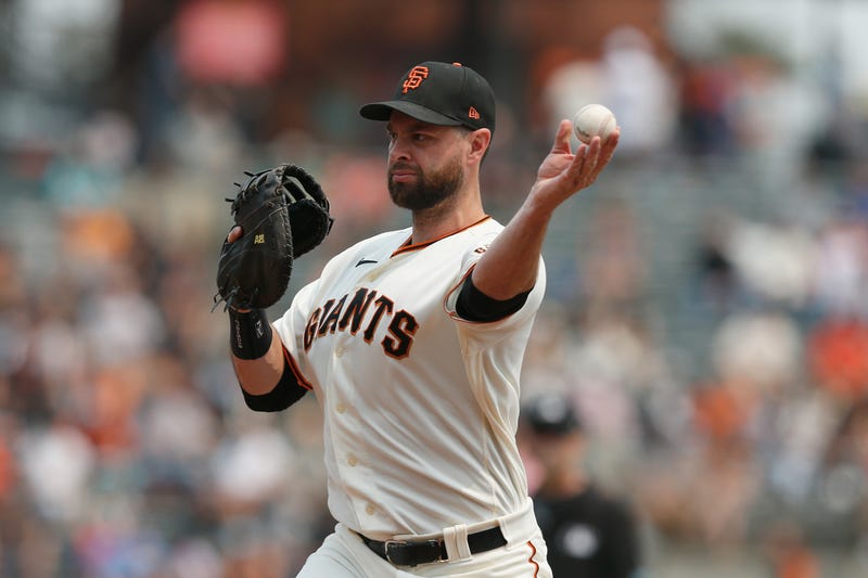 Brandon Belt #9 of the San Francisco Giants throws the ball to pitcher Anthony DeSclafani #26 covering first to get the out of Dominic Smith #2 of the New York Mets in the top of the second inning at Oracle Park on August 18, 2021 in San Francisco, California.