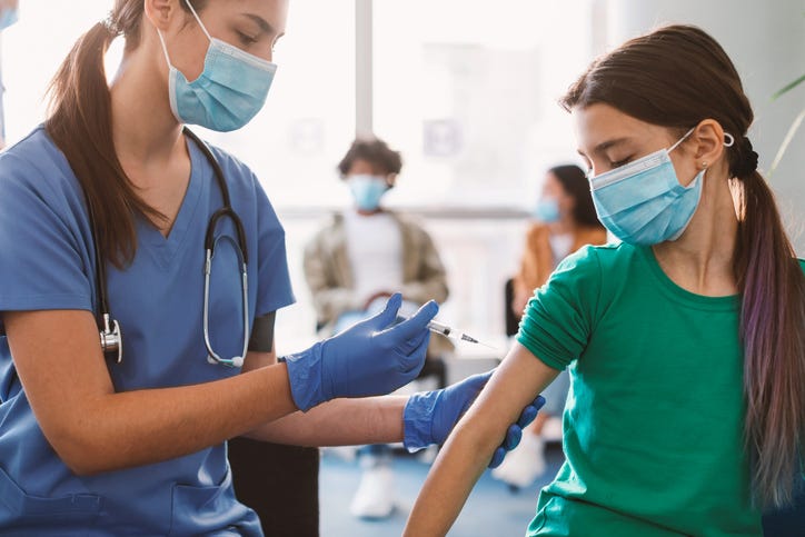 Nurse giving a child a COVID-19 vaccine. 