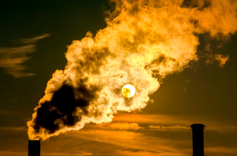The sun shines through the exhaust gases of a power plant.
