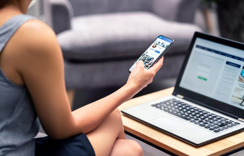 person using social media on a phone and laptop