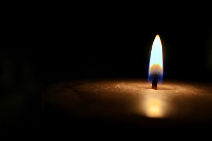 Isolated glowing candle on black background