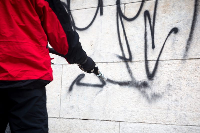 worker washing graffitti