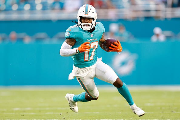 Jaylen Waddle models the Dolphins aqua uniform tops. 