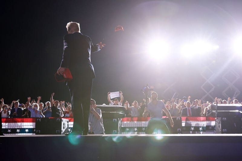Former President Donald Trump tosses a MAGA hat to a supporter at the "Save America" rally on August 121, 2021, in Cullman, Alabama.