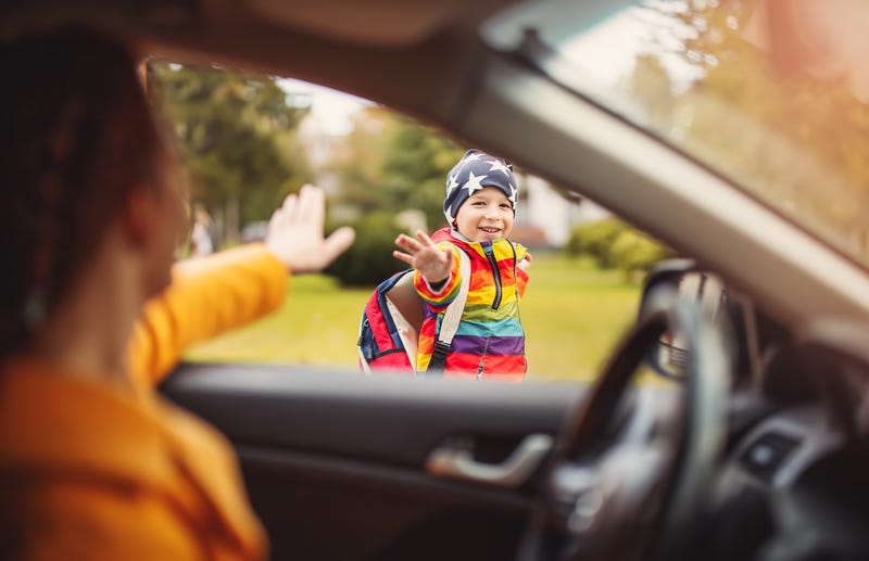 parent waving to kid from car
