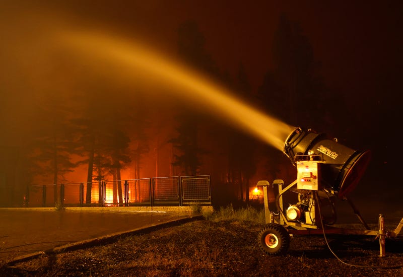 A snow machine blows water on a structure at Sierra-at Tahoe ski resort as the Caldor Fire moves through the area on August 30, 2021 in Twin Bridges, California.