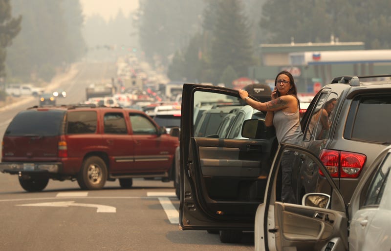 A woman talks on her phone while stopped in heavy traffic on Highway 50 as people evacuate ahead of the Caldor Fire in South Lake Tahoe.
