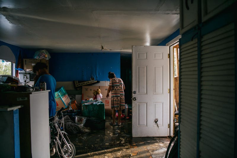 The Maldonado family walk through their home after it flooded during Hurricane Ida.