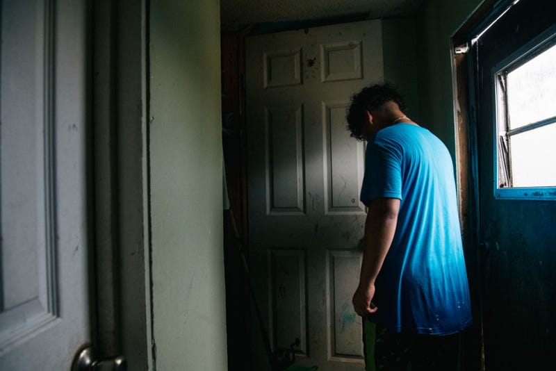 A member of the Maldonado family walk through the house after it flooded during Hurricane Ida.