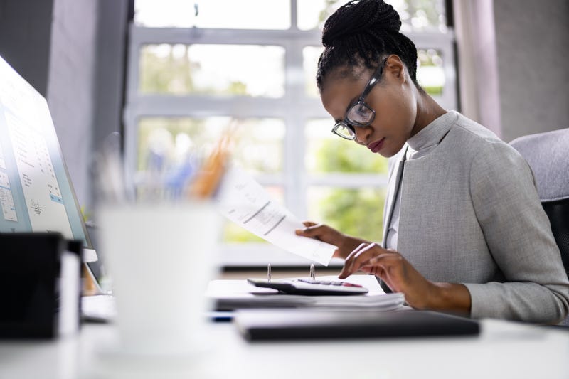 Woman typing on calculator