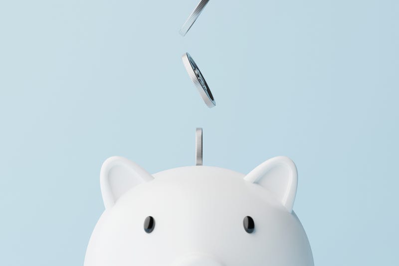 Coins going into a piggy bank.