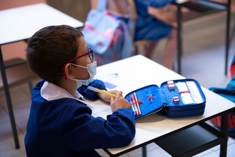A child wears a protective mask inside an elementary school classroom.