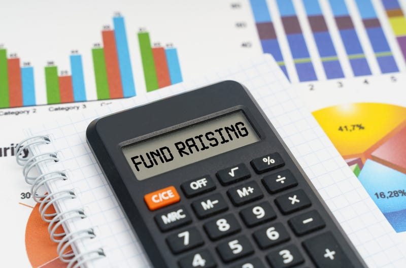 Business and economy concept. On the table are charts, a notebook and a calculator with the inscription - FUND RAISING