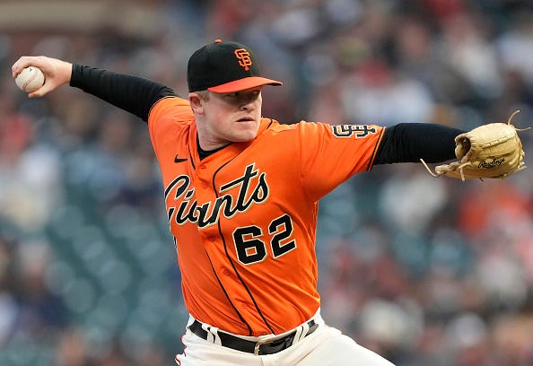 Logan Webb models the orange alternate tops of the Giants.