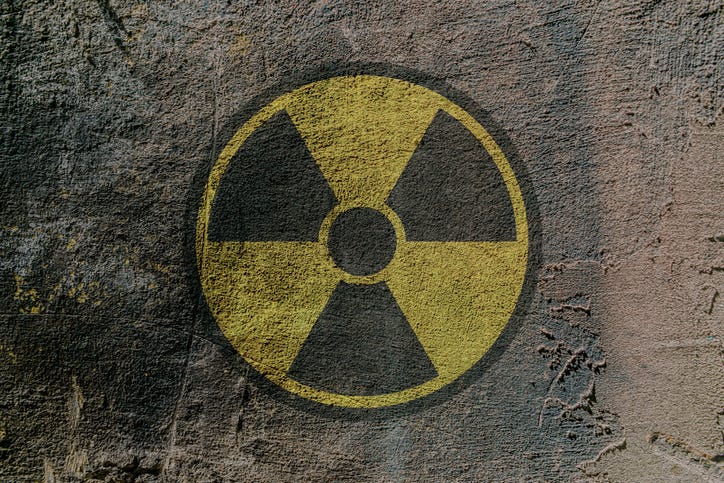 Radiation hazard warning sign depicted on a concrete wall.