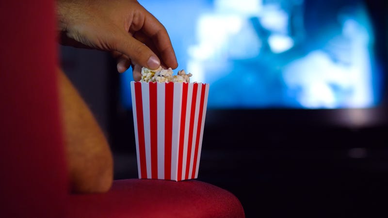 Person in movie theater eating popcorn